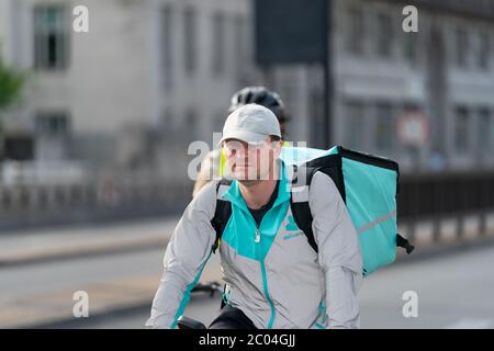 Deliveroo consegna ciclista nel centro di Londra, Inghilterra durante il Coronavirus COVID-19 pandemico blocco sul Waterloo Bridge, Londra Foto Stock