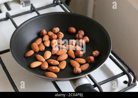 Mandorle e nocciole tostate noci in padella sulla stufa Foto Stock