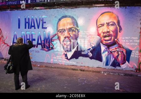 Un uomo scatta una foto di un murale che mostra Malcolm X e Martin Luther King Jnr a Waterloo, Londra, dopo una serie di proteste Black Lives Matter che si sono svolte in tutto il Regno Unito nel fine settimana. Le proteste sono state scatenate dalla morte di George Floyd, ucciso il 25 maggio mentre era in custodia di polizia nella città americana di Minneapolis. Foto Stock