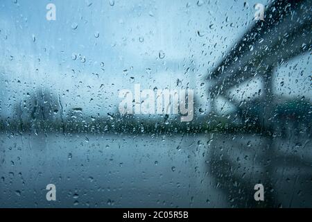 guida in condizioni di pioggia intensa, specialmente intorno ai veicoli. pioggia sul finestrino di un'auto. Foto Stock