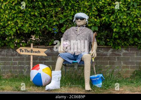 Sentiero o festival dello Scarecrow, parte delle celebrazioni del carnevale Old Basing, Hampshire, Regno Unito. Spaventapasseri vestito per la spiaggia. Foto Stock