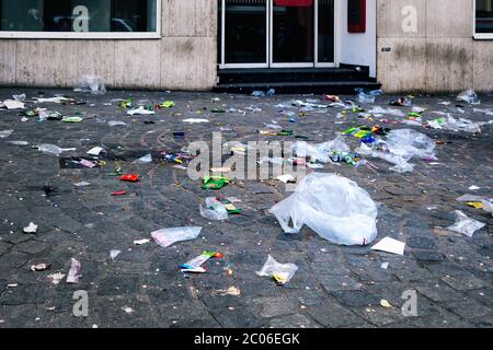 Borse vuote, confezioni, decorazioni festival e altri rifiuti sono giacenti sul marciapiede e sulla strada dopo la tradizionale sfilata di carnevale. Foto Stock