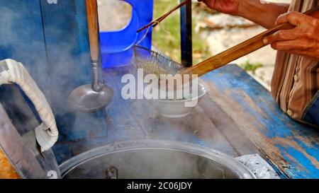 i venditori di pasta di pollo di strada preparano i menu del cibo sul carrello. Immagine a fuoco non, rumore e messa a fuoco selettiva sfocata Foto Stock