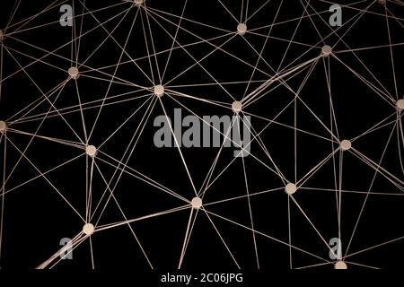 Una rete complessa di fili bianchi intrecciati tra punti in movimento su uno sfondo scuro. Foto Stock