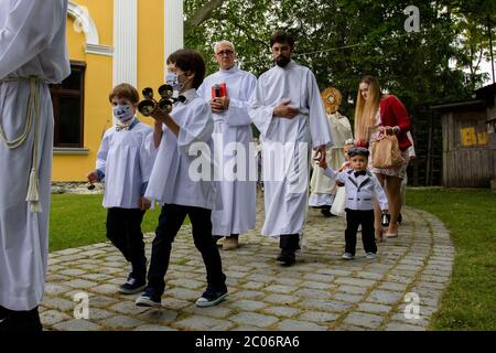 Albanesi che indossano maschere alla parrocchia della Beata Vergine Maria di Czestochowa, in via Kochanowskiego, durante la processione.Festa del corpo e del sangue di Cristo (Corpus Christi) È una festa dedicata alla venerazione del corpo e del sangue di Cristo, in cui il pane e il vino si trasformano durante l'Eucaristia secondo la fede cristiana. Secondo la tradizione, in questo giorno si organizza una solenne processione per le strade della Chiesa cattolica. In Polonia, questo giorno è una festa pubblica. Quest'anno, molti partecipanti alla processione indossavano maschere mediche, tra cui l'alt Foto Stock