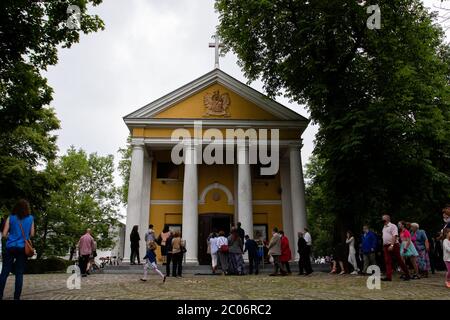 Devoti visti fuori dalla parrocchia della Beata Vergine Maria di Czestochowa, in via Kochanowskiego, durante l'evento. Festa del corpo e del sangue di Cristo (Corpus Christi) È una festa dedicata alla venerazione del corpo e del sangue di Cristo, in cui il pane e il vino si trasformano durante l'Eucaristia secondo la fede cristiana. Secondo la tradizione, in questo giorno si organizza una solenne processione per le strade della Chiesa cattolica. In Polonia, questo giorno è una festa pubblica. Quest'anno, molti partecipanti alla processione indossavano maschere mediche, tra cui server di altare e monache. Foto Stock