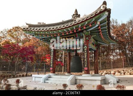 Grande Campana Buddista in un Padiglione con ornamenti verdi e rossi nella DMZ in Corea del Sud Foto Stock