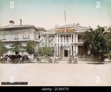 [ 1880's Japan - Kobe Oriental Hotel ] - Rickshaws di fronte all'originale Oriental Hotel al n. 80 nell'insediamento straniero a Kobe, Prefettura di Hyogo. fotografia albumen d'epoca del xix secolo. Foto Stock