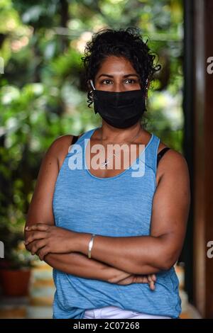 Ritratto interno di donna che indossa una maschera facciale Foto Stock