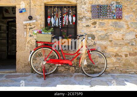 Autentica casa in pietra della città vecchia di Datca e una bici rossa si erge nella parte anteriore con scopo decorativo. I magneti del frigorifero sono visualizzati sulla parete. Foto Stock