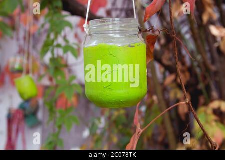 Vaso di vetro verde riciclato come lampada da giardino decorativa Foto Stock