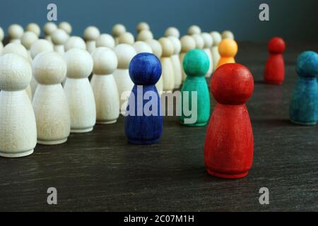 Concetto inclusivo e di discriminazione. Linee di figurine in legno e diverse come simbolo della diversità. Foto Stock