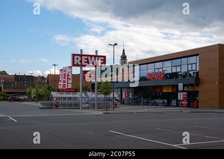 Grande supermercato Rewe a Tauberbischofsheim Baden Württemberg con la città vecchia e la chiesa sullo sfondo. Foto Stock
