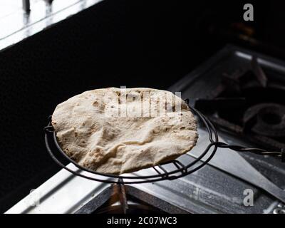 Modo tradizionale di fare roti / Chapati / Tava Roti indiani, in casa indiana. Foto Stock