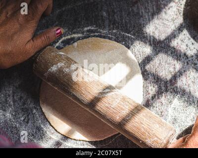 Modo tradizionale di fare roti / Chapati / Tava Roti indiani, in casa indiana. Foto Stock