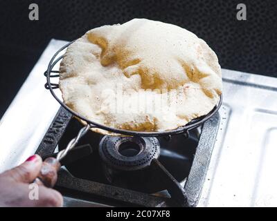 Modo tradizionale di fare roti / Chapati / Tava Roti indiani, in casa indiana. Foto Stock