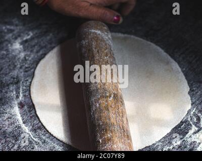 Modo tradizionale di fare roti / Chapati / Tava Roti indiani, in casa indiana. Foto Stock