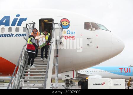 Calum Best (a sinistra) e Tamer Hassan aiutano a scaricare scatole di dispositivi di protezione personale (PPE) da un aereo all'aeroporto Robin Hood di Doncaster, nello Yorkshire del Sud. ??30,000 il valore di PPE è stato donato alla carità Mask Our Heroes, che è stata istituita dall'imprenditore Matthew McGahan sulla scia dell'epidemia di coronavirus per aiutare a fornire i dispositivi di protezione di cui hanno bisogno ai lavoratori della prima linea NHS e della salute. Foto Stock