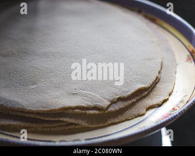 Modo tradizionale di fare roti / Chapati / Tava Roti indiani, in casa indiana. Foto Stock