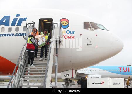 Calum Best (a sinistra) e Tamer Hassan aiutano a scaricare scatole di dispositivi di protezione personale (PPE) da un aereo all'aeroporto Robin Hood di Doncaster, nello Yorkshire del Sud. ??30,000 il valore di PPE è stato donato alla carità Mask Our Heroes, che è stata istituita dall'imprenditore Matthew McGahan sulla scia dell'epidemia di coronavirus per aiutare a fornire i dispositivi di protezione di cui hanno bisogno ai lavoratori della prima linea NHS e della salute. Foto Stock