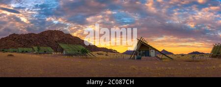 Sunrise sopra i piccoli chalets di una desert lodge vicino al Sossusvlei in Namibia Foto Stock