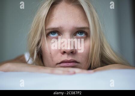 La ragazza sta posando a letto essendo malata e annoiata Foto Stock