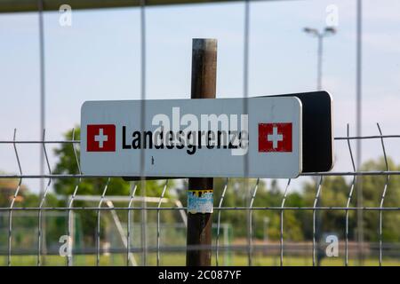 Wegen der Ausbreitung des Corona-Virus haben die Schweiz und Deutschland ihre Grenzen geschlossen. Nun findet die Konversation am Grenzaun statt. Kon Foto Stock