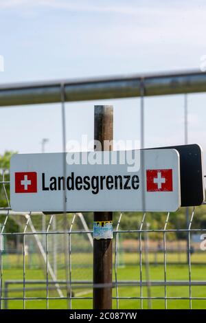 Wegen der Ausbreitung des Corona-Virus haben die Schweiz und Deutschland ihre Grenzen geschlossen. Nun findet die Konversation am Grenzaun statt. Kon Foto Stock