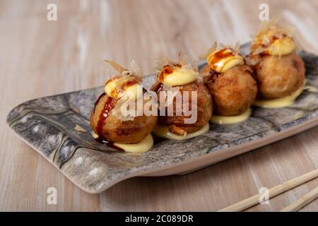 Cibo giapponese Takoyaki polpo palle su sfondo di legno Foto Stock