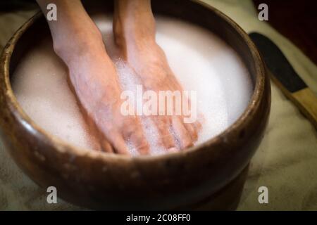 I piedi si immergersi in acqua dolce in una spa di bellezza per unghie. Foto Stock