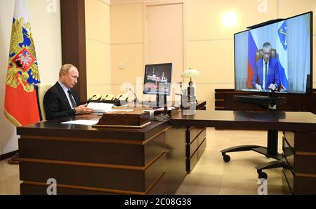 Il presidente russo Vladimir Putin, tiene un incontro in videoconferenza con il governatore della regione di Leningrad Alexander Drozdenko dal suo ufficio presso la residenza di stato di Novo-Ogaryovo il 10 giugno 2020 fuori Mosca, Russia. Foto Stock