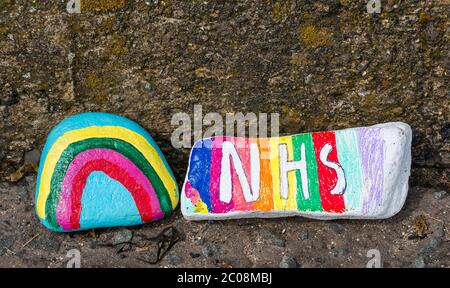 Port Seton, East Lothian, Scozia, Regno Unito. 11 Giugno 2020. Covid-19 simboli pandemici creati dalla gente del posto: Una linea lunga centinaia di piedi sul lungomare di pietre colorate e creative dipinte a mano con messaggi ispiranti. Sembra essere un fenomeno che si diffonde intorno alle città e villaggi della Lotia orientale. Pietre con un simbolo arcobaleno di speranza e un ringraziamento a NHS Foto Stock