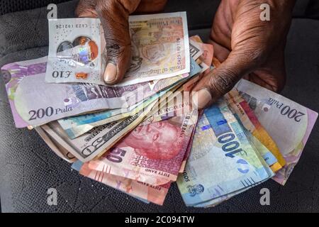 Molti abitanti dello Zimbabwe si occupano quotidianamente di una miriade di valute provenienti dagli Stati Uniti, dal Botswana, dalla Gran Bretagna e da altri paesi. I tassi di cambio sono fissati per quelle valute così come per il denaro locale mobile, le obbligazioni e altro ancora, ma ogni tasso di cambio cambia da minuto a minuto sul mercato nero. (Linda Mujuru, GPJ Zimbabwe) Foto Stock