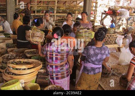 Donne locali vestite in batik che preparano offerte per una festa imminente, a Bali, Indonesia Foto Stock