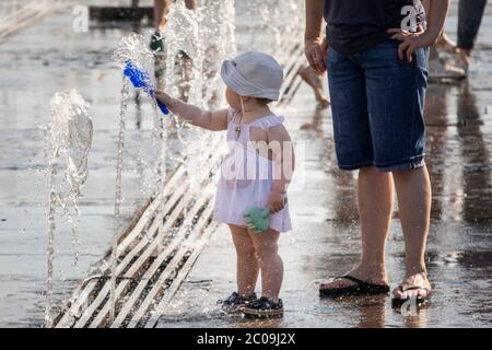 Mosca, Russia. 11 giugno, 2020 persone bagnano in una fontana a terra nel Parco Muzeon sull'argine di Krymskaya durante il tempo caldo anormale a Mosca, Russia. Il 11 giugno la temperatura di Mosca raggiunse i 30°C. Foto Stock