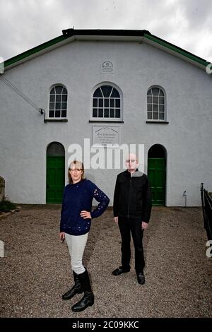 Alan McGee, l'imprenditore scozzese e l'esecutivo dell'industria musicale, ha ritratto con il suo partner fuori dalla cappella del Tabernacolo a Talgarth, che ha acquistato Foto Stock