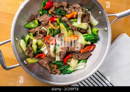 Verdure sane e manzo fritto. Composto da bistecca, peperoni, cipolle e bok choy fritti in un wok asiatico. Foto Stock