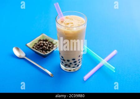 Un bicchiere di gorgoglietta di tè al latte fatta in casa, con palle di ghiaccio e tapioca (chiamate anche perle). Il tè delle bolle è una bevanda rinfrescante, molto popolare a taiwan. Foto Stock