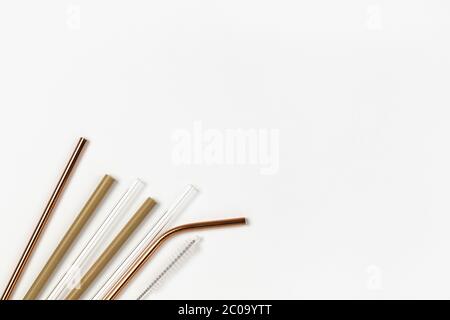 Tubi da metallo, vetro, bambù riutilizzabili per uso ambientale, contro tubi monouso in plastica. Sfondo bianco. Orizzontale. Spazio di copia. Piatto, clo Foto Stock