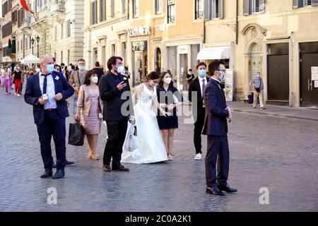 Sposato di recente e alcuni amici invitati al matrimonio, indossando una maschera medica per il Coronavirus Covid 19, a piedi per la scalinata di Spagna. Roma al tempo del Covid 19 fase 2, due. Italia, Europa, Unione europea, UE. Foto Stock
