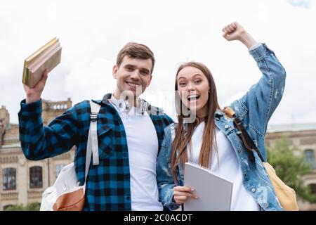 studenti allegri che celebrano il trionfo guardando la macchina fotografica Foto Stock