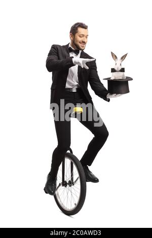Mago che cavalcano un monociclo e che esegue un trucco con un coniglio isolato su sfondo bianco Foto Stock