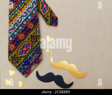 Concetto del giorno del padre - cravatta colorata hipster, baffi, cuore su sfondo di legno Foto Stock
