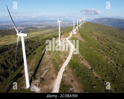 Vista aerea della fattoria dei mulini a vento per la produzione di energia rinnovabile sul bel cielo blu. Turbine eoliche che generano energia pulita rinnovabile per lo sviluppo sostenibile. Fotografia di alta qualità. Foto Stock
