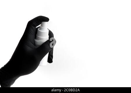 Il guanto in nitrile nero a mano contiene lo spray per la disinfezione. Spazio libero per il testo. Foto Stock