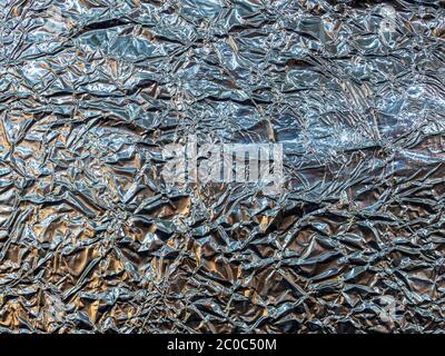 Struttura di fondo in lamina di alluminio sminuzzata. Superficie lucida e rugosa. Foto Stock