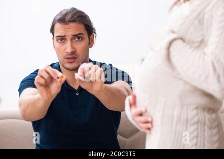 Uomo e donna incinta nel concetto di antifumo Foto Stock