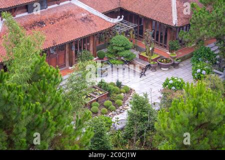 Vista incredibile del monastero buddista sul tetto e giardino cortile con fiori e alberi bonsai in collina Bana, sito turistico a da Nang, Vietnam Foto Stock