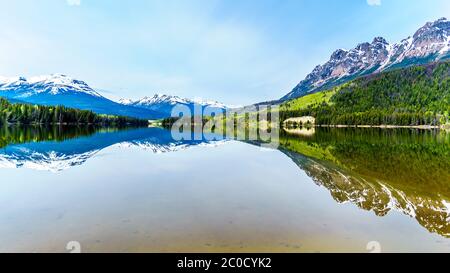 Riflesso della catena delle Montagne Rocciose sulla superficie liscia del lago Yellowhead nel Robson Provincial Park nella British Columbia, Canada Foto Stock