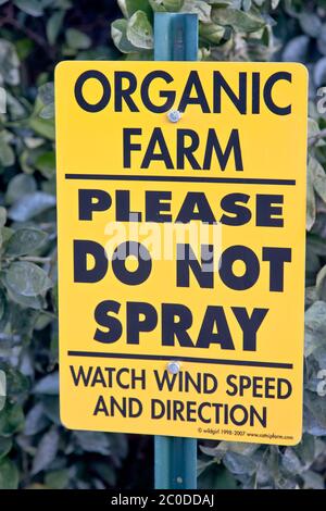 Posted segno a Orange frutteto, 'SI PREGA DI NON SPRUZZARE - GUARDARE VENTO VELOCITÀ E DIREZIONE', frutteto di agrumi biologici, California. Foto Stock